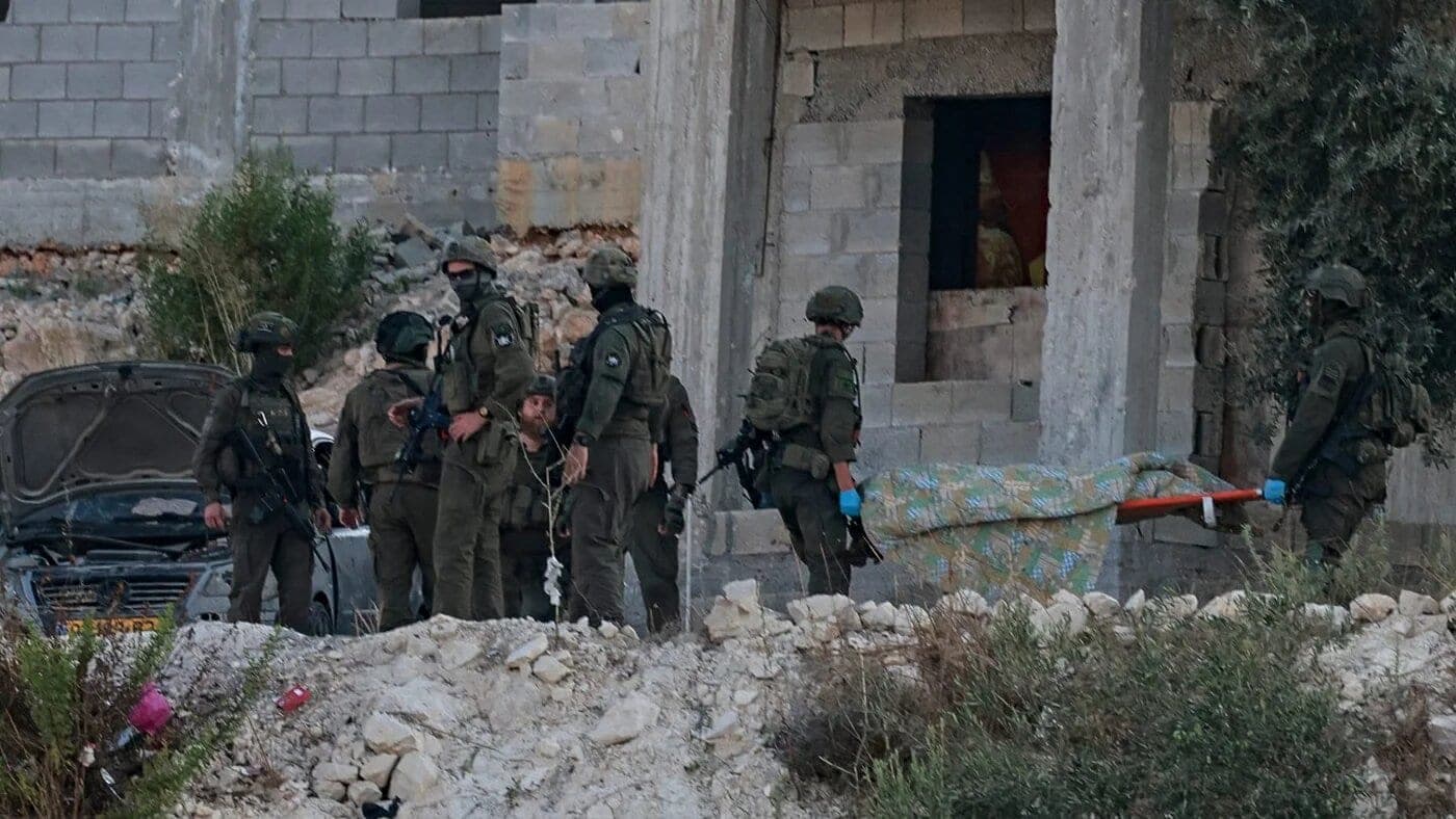 Israeli soldiers remove the body of a Palestinian from a house under construction in Jenin, occupied West Bank, 28 August 2026 (Jaafar Ashtiyeh/AFP)